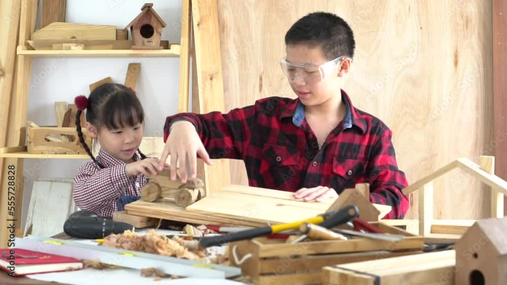 Two Asian boy and girl play together in carpentry shop with fun and cheerful, sibling in plaid shirt focus to learn how to move wooden car toy, boy with safety eye glasses enjoy with cute sister
Two Asian boy and girl play together in carpentry shop with fun and cheerful, sibling in plaid shirt focus to learn how to move wooden car toy, boy with safety eye glasses enjoy with cute sister