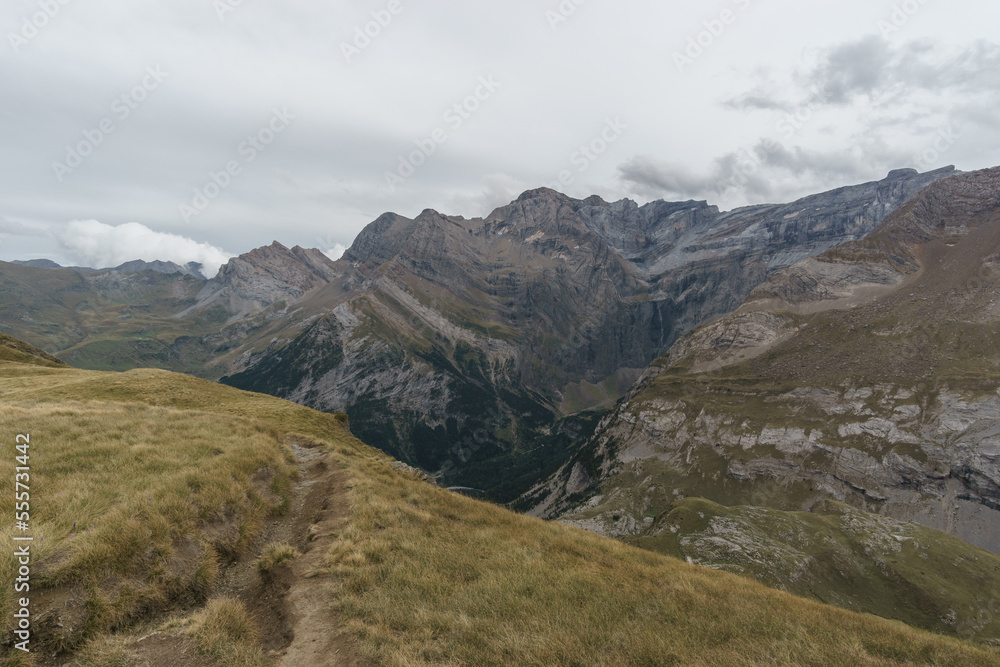 Beautiful high mountain landscape with view at the Cirque de Gavarnie and waterfall with footpath in the Pyrenees, Nouvelle-Aquitaine, France Beautiful high mountain landscape with view at the Cirque de Gavarnie and waterfall with footpath in the Pyrenees, Nouvelle-Aquitaine, France