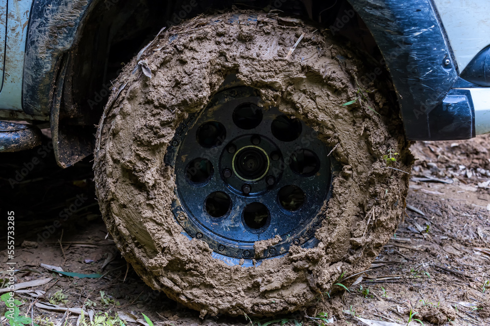 Tire has been mired in the mud. Wheel closeup with a muddy. Wheel of tire is dirty because mud Tire has been mired in the mud. Wheel closeup with a muddy. Wheel of tire is dirty because mud
