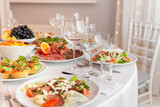 Served for holiday banquet restaurant table with dishes, snack, cutlery, wine and water glasses.