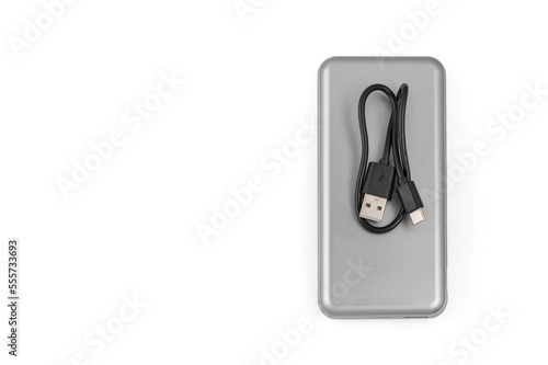 Additional autonomous power bank for charging mobile devices. External battery isolated on white background. Silver charger for a smartphone with a power supply (battery). Top view.