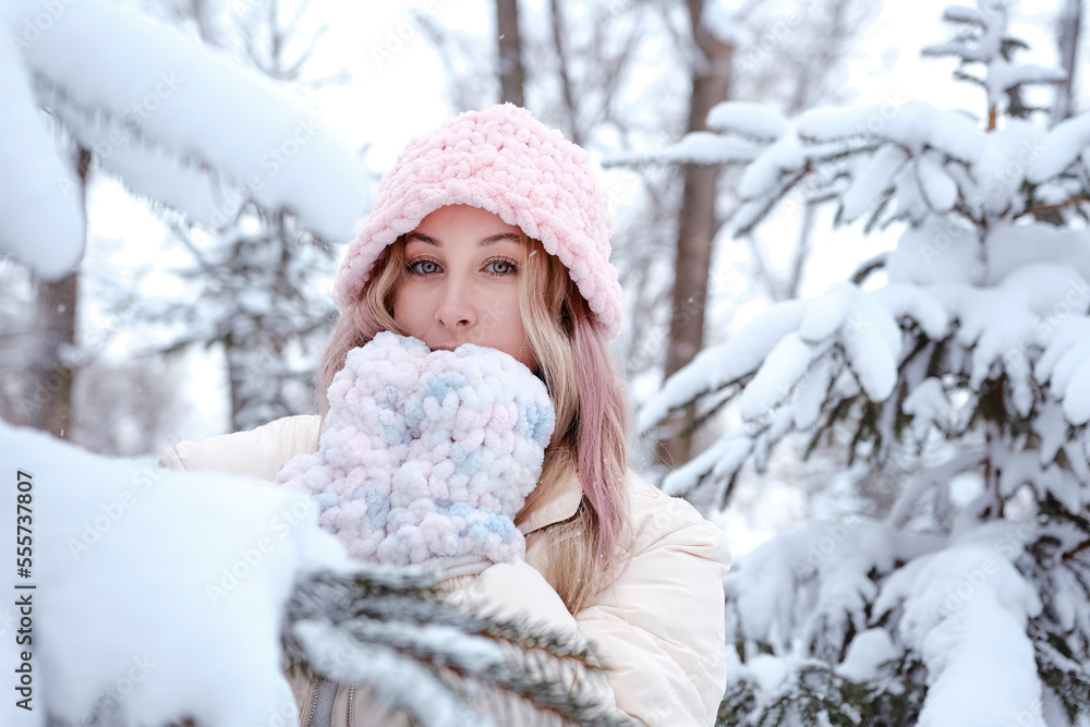 Obraz premium Winter woman in snow looking at camera outside on snowing cold winter day. Portrait Caucasian female model outside in first snow