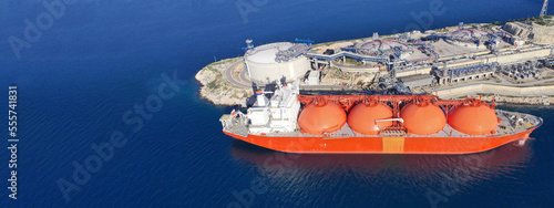 Aerial drone ultra wide photo of LNG (Liquified Natural Gas) tanker anchored in small LNG industrial islet of Revithoussa equipped with tanks for storage, Salamina, Greece