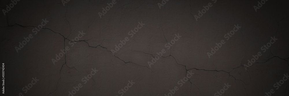 Obraz premium Texture of the old wall. Rough grungy surface of painted plastered concrete wall with spots, cracks, noise and grain. Dark wide panoramic background for design. Shaded vintage texture with vignette.