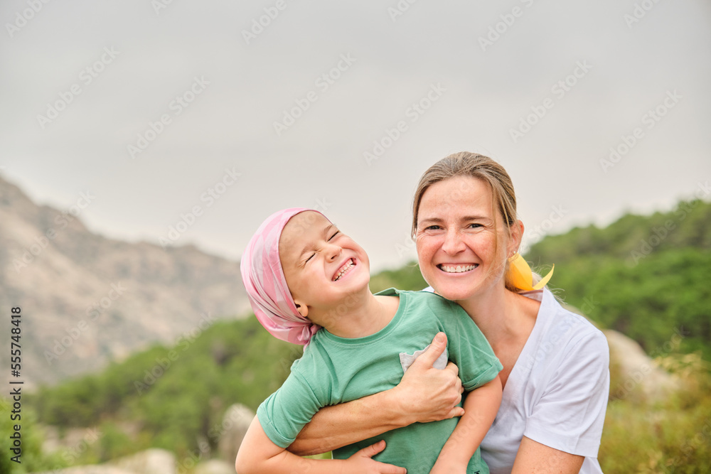 Nurse plays with her young cancer patient in the wilderness