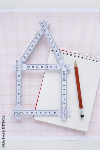 Folding Ruler in Shape of House with Pencil and Notepad photo