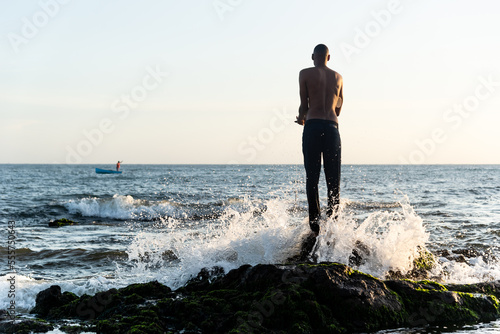 Fotografiet A fisherman on top of the rocks fishing.