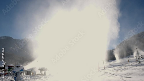 Snowmaking machine snow cannon or gun in action on a cold sunny winter day in ski resort Kranjska Gora, Slovenia. photo