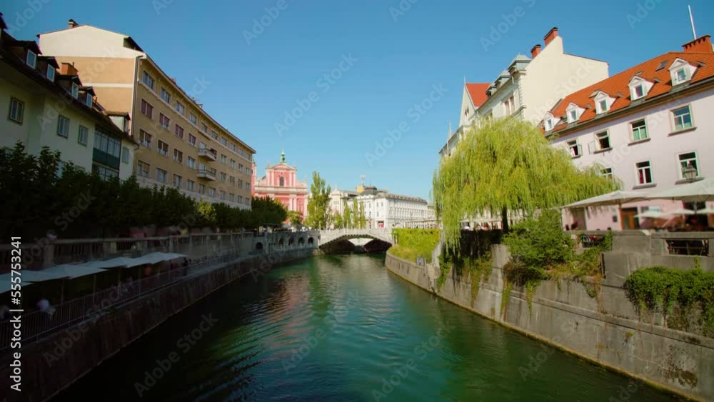 Long water channel with granite banks and hanging plants runs across town along street with historical houses in Ljubljana Slovenia Long water channel with granite banks and hanging plants runs across town along street with historical houses in Ljubljana Slovenia