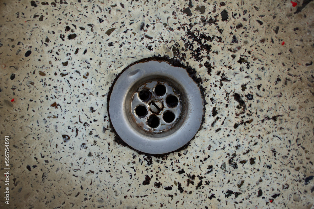 Foto de Metal drain of a stone sink interspersed with stone chips
