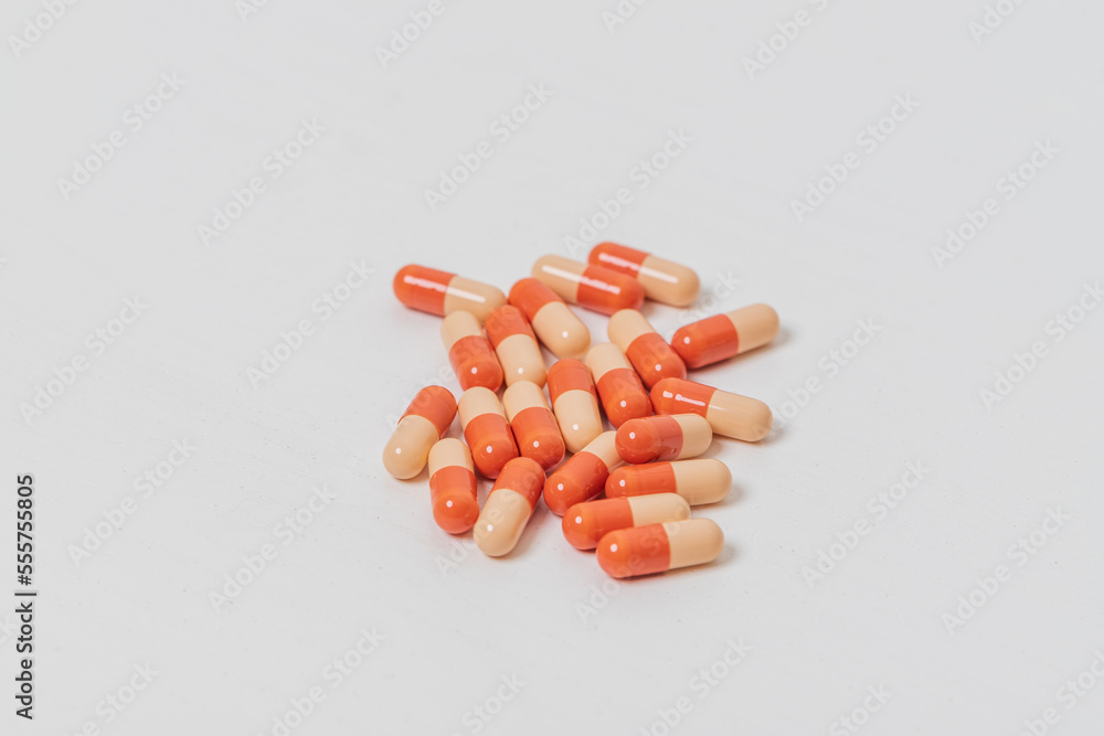 Capsules of pills lie on a white table. Capsules of pills lie on a white table.