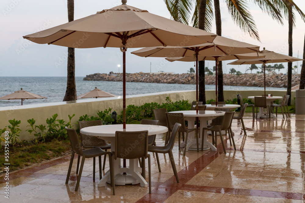 tables et parasols avec vue sur la mer lors d'une journée pluvieuse