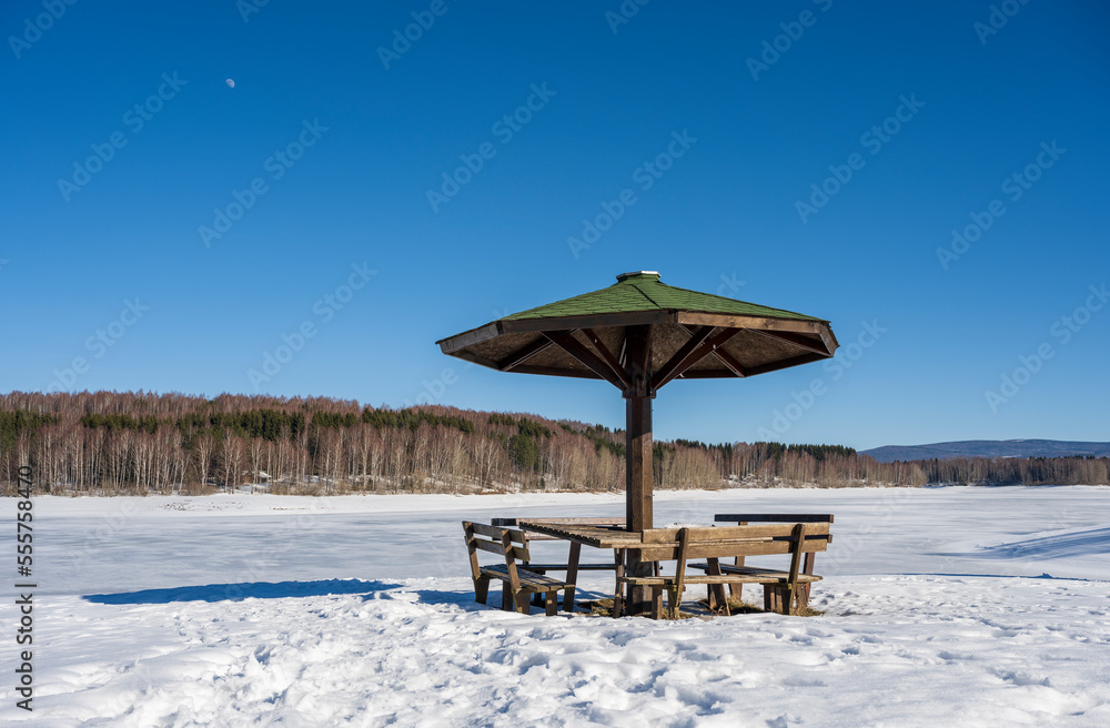 Winter landscape by the frozen lake with hills in the background background. Frozen Lake on a cold winter day Winter landscape by the frozen lake with hills in the background background. Frozen Lake on a cold winter day