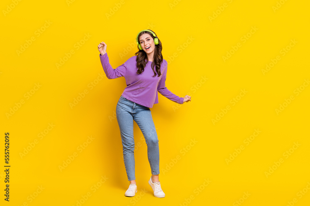 Full body portrait of overjoyed cheerful lady have fun dancing listen new single isolated on yellow color background Full body portrait of overjoyed cheerful lady have fun dancing listen new single isolated on yellow color background