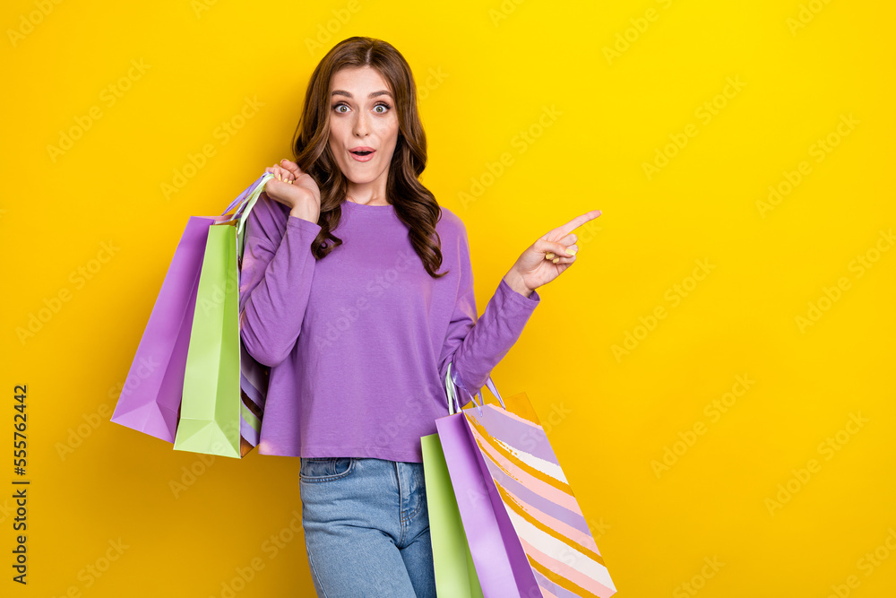 Portrait of pretty impressed lady direct finger empty space offer isolated on yellow color background Portrait of pretty impressed lady direct finger empty space offer isolated on yellow color background