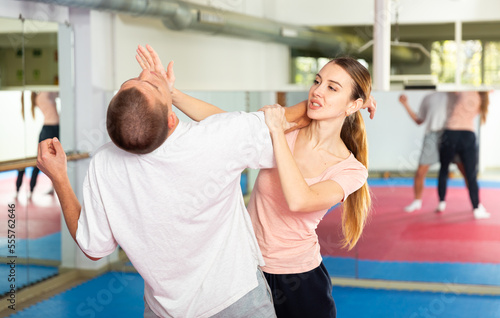 Active girl conducts painful grip on self-defense training in the gym