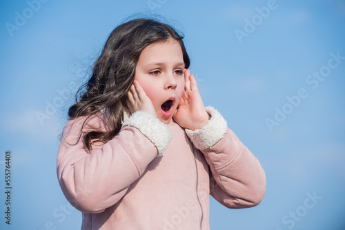 child with shocked face on sky background