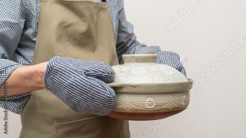 鍋つかみ(ミトン)で熱々の鍋を持つ イメージ