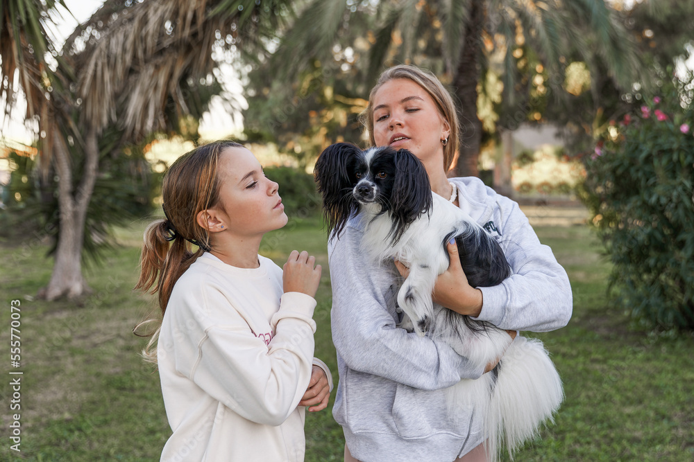 Girls playing with a dog in the park Girls playing with a dog in the park