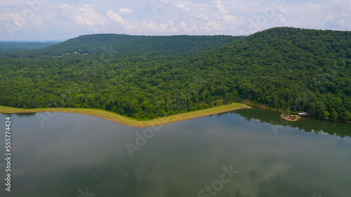 Aerial Landscape of river by the parcels of land in the woods full of green trees