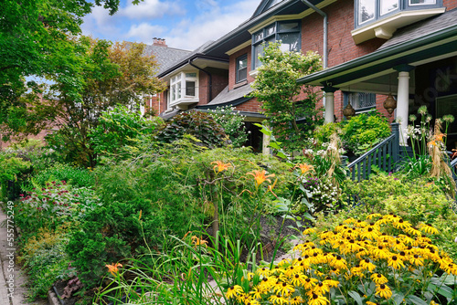 Fototapeta Naklejka Na Ścianę i Meble -  Residential street with older homes and front yards full of flowers