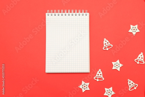 Christmas New Year background White notebook for wishes, goals, recipes, plans, solutions for start of new year on red background among Christmas decorations