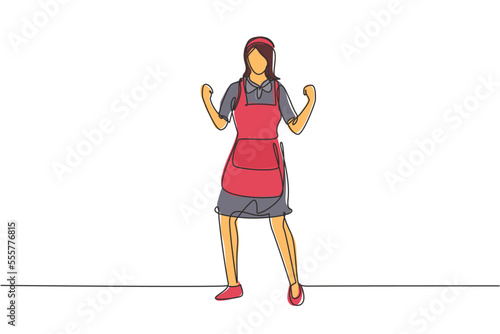 Single one line drawing maid in hotel stood with celebrate gesture and uniform clean up bed, bed sheet, blanket, pillow in hotel room. Modern continuous line draw design graphic vector illustration