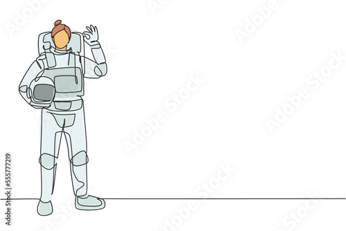 Single continuous line drawing female astronaut stands with gesture okay wearing space suit exploring earth, moon, other planets in universe. Dynamic one line draw graphic design vector illustration