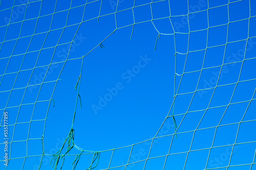 Close-up of Hole in Net against Blue Sky