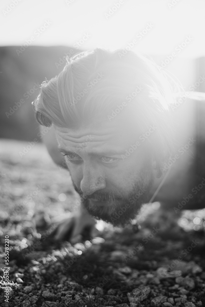 Muscular modern guy doing push-ups on top of mountain in nature Muscular modern guy doing push-ups on top of mountain in nature