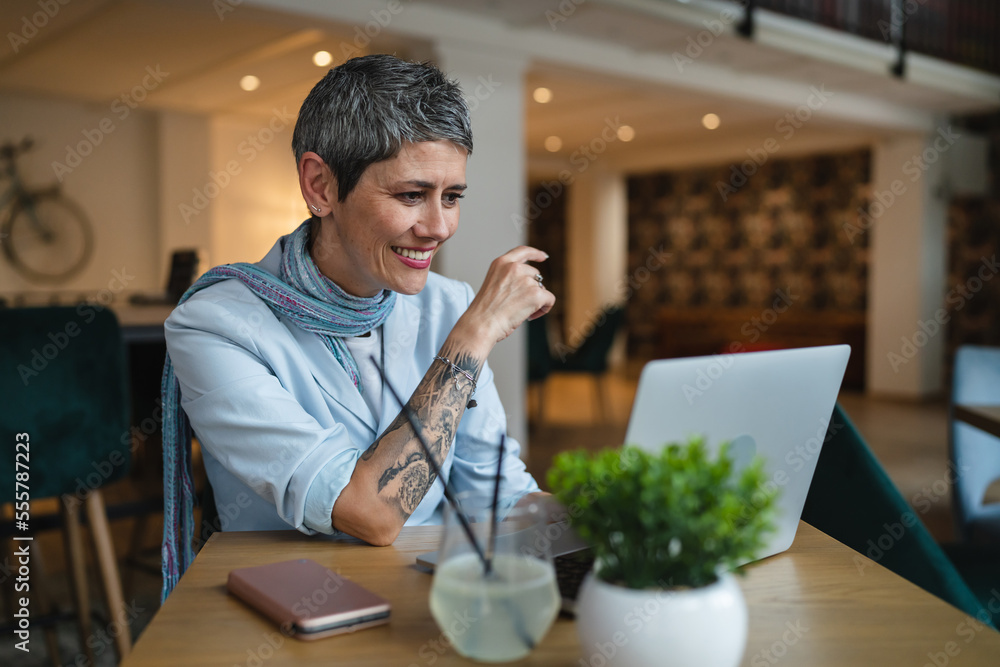 One woman mature adult senior female work on laptop at cafe One woman mature adult senior female work on laptop at cafe