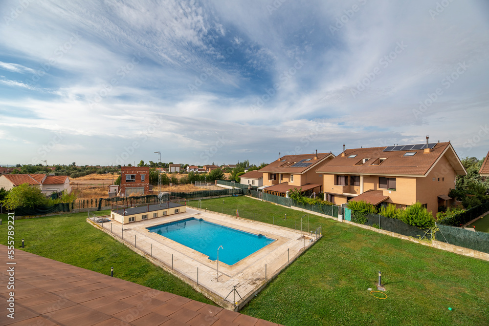 Common pool of residential houses with single-family homes with a lot of grass and no shade