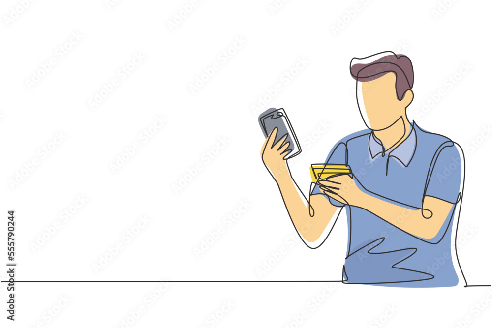 Single one line drawing young man sitting on chair and typing entering credit card code on laptop around desk. Digital payment concept. Modern continuous line draw design graphic vector illustration