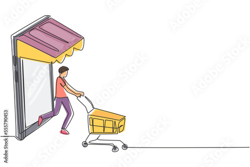 Continuous one line drawing young man coming out of canopy smartphone screen pushing a shopping cart. Sale, digital lifestyle, consumerism concept. Single line draw design vector graphic illustration