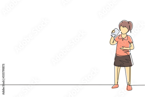Single continuous line drawing girl standing while drinking a glass of milk to fulfill body's nutrition. Healthy lifestyles concept for kids. Dynamic one line draw graphic design vector illustration