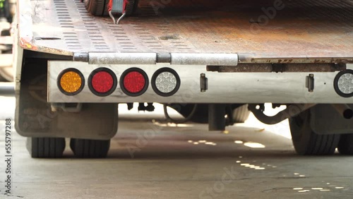 Car tire secured with belt for safety on flatbed tow truck,Securing the load of a car transporter,