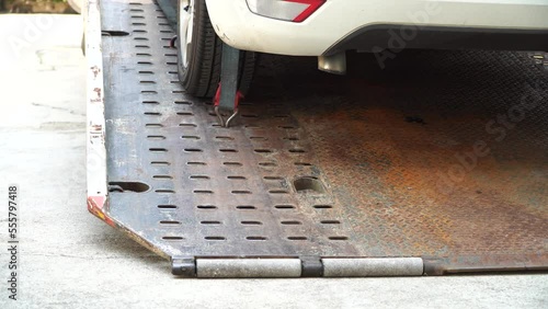Car tire secured with belt for safety on flatbed tow truck,Securing the load of a car transporter,