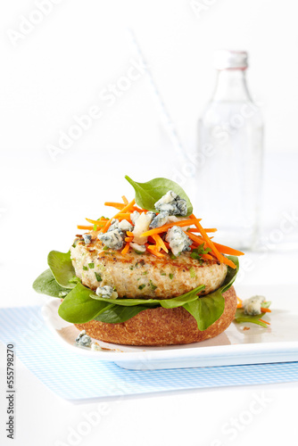 Open-faced, buffalo chicken burger with blue cheese on plate, studio shot on white background photo