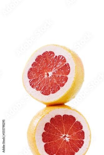 Two pink grapefruit halves stacked on top, studio shot on white background photo