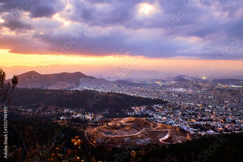 sunset with city in the background and mountains in foreground, sierra de guadalupe state of mexico and mexico city 