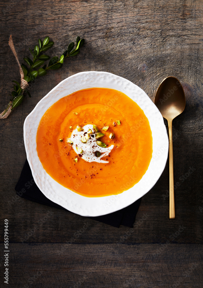 Sweet potato soup in a white bowl with cream Sweet potato soup in a white bowl with cream