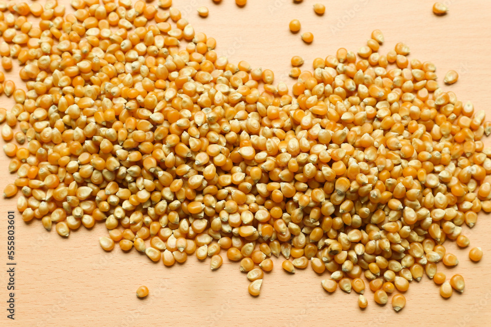 Pile of yellow corn seeds isolated on brown wooden background, for popcorn. Pile of yellow corn seeds isolated on brown wooden background, for popcorn.