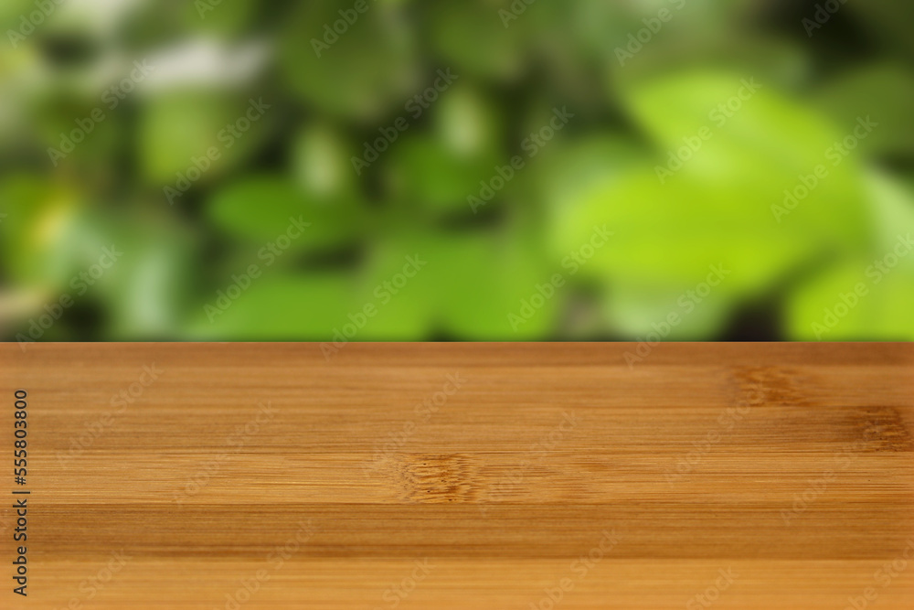 bamboo table view with blurred green leaves bokeh perspective background. bamboo table view with blurred green leaves bokeh perspective background.