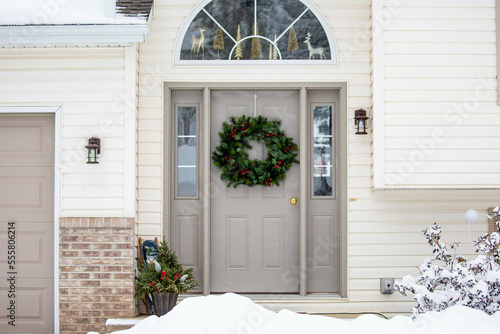 Front door with Christmas wreath and snow