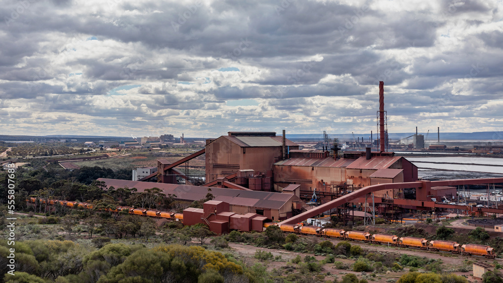 Industrial landscape of steelworks pelletising plant & train delivering iron ore from the mine Industrial landscape of steelworks pelletising plant & train delivering iron ore from the mine