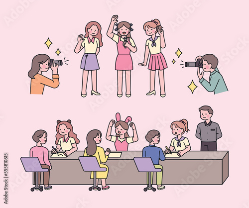 A girl idol is holding a fan meeting event. Fans take pictures of idols. They are having a conversation at the table.