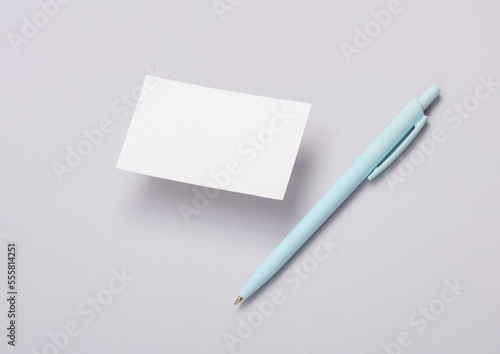 Blank business card and pen on gray background. Mockup for presentations and corporate identity
