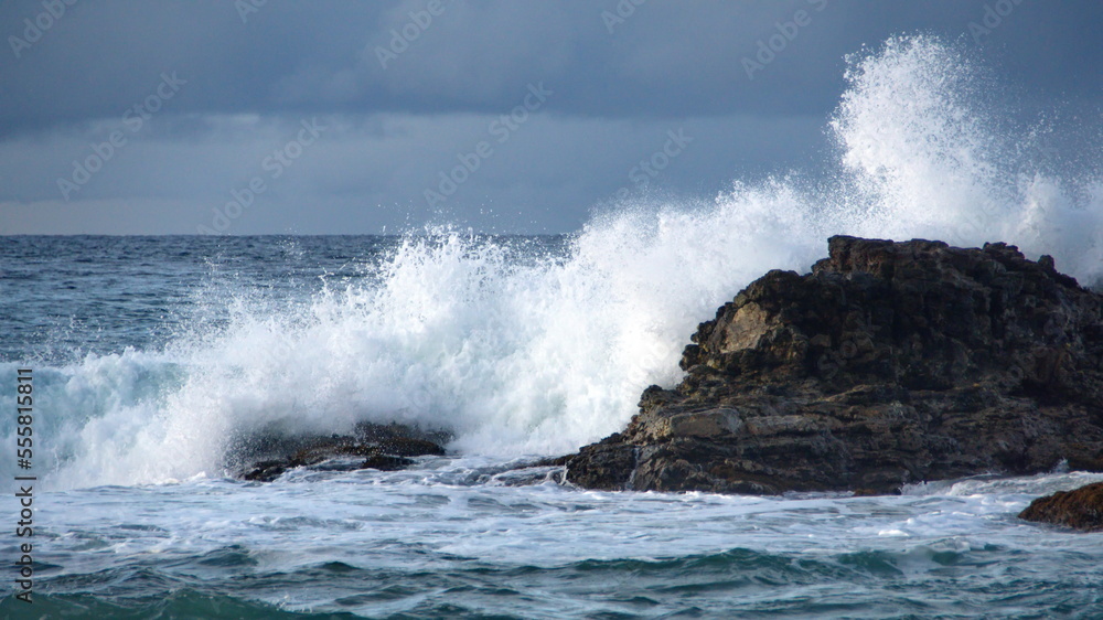 Waves breaking on a rock just off the beach in Zipolite, Mexico