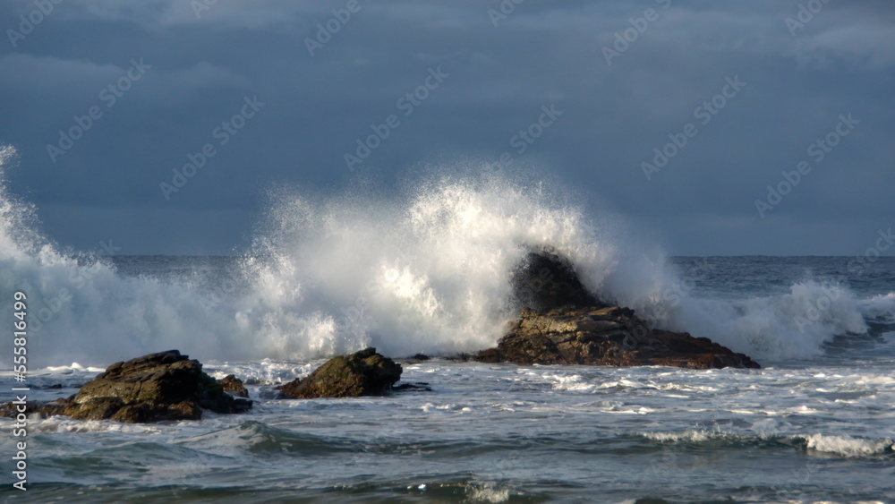 Waves breaking on a rock just off the beach in Zipolite, Mexico