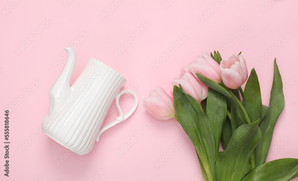 Bouquet of pink tulips with a ceramic teapot on a pink background. Top view Bouquet of pink tulips with a ceramic teapot on a pink background. Top view